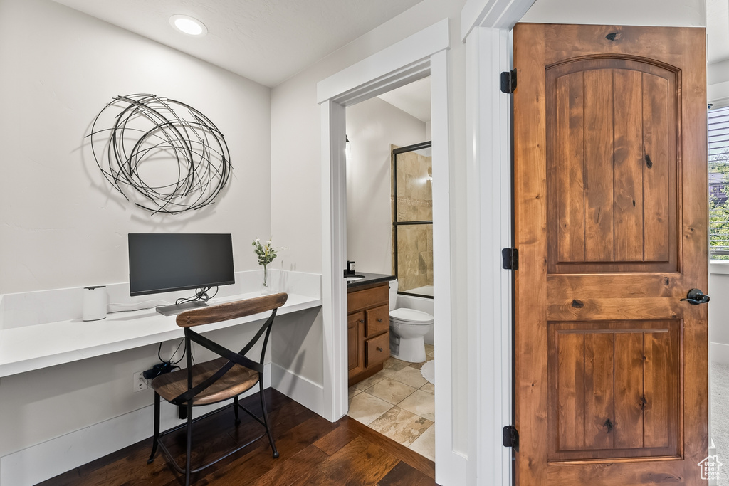 Office area featuring built in desk and hardwood / wood-style floors