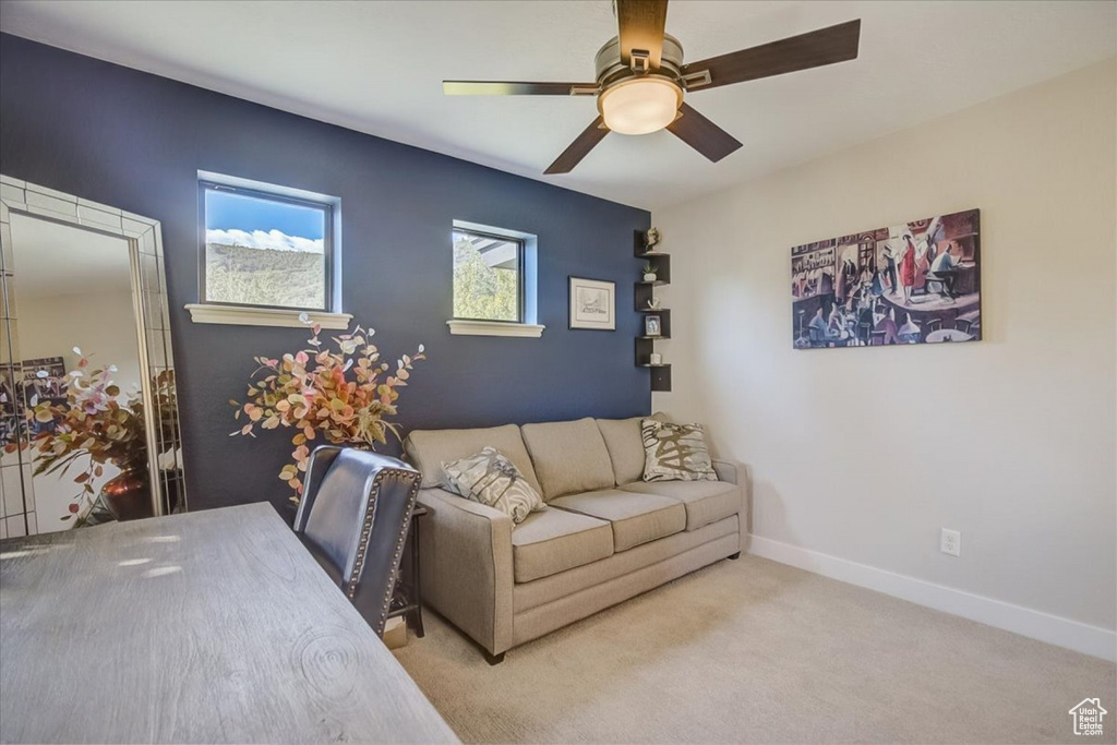 Carpeted living room featuring ceiling fan