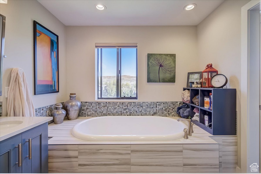 Bathroom with tiled tub and vanity