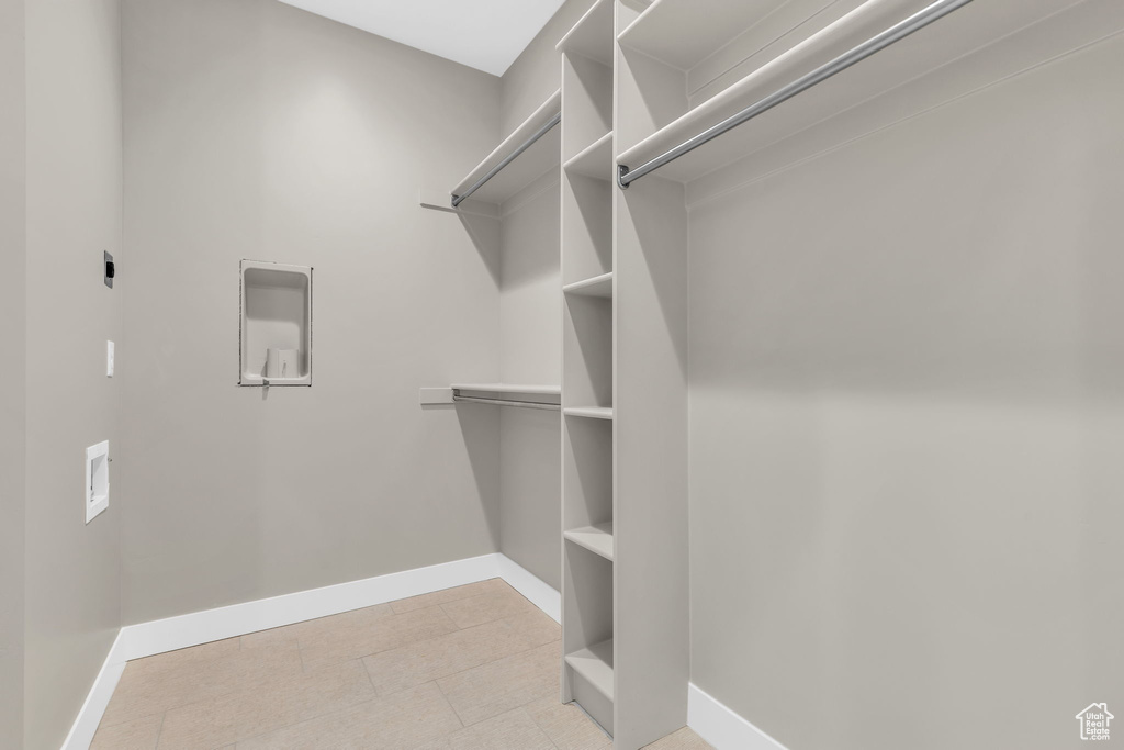 Spacious closet featuring light tile floors