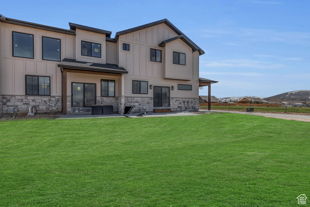 Rear view of house with a patio area and a yard