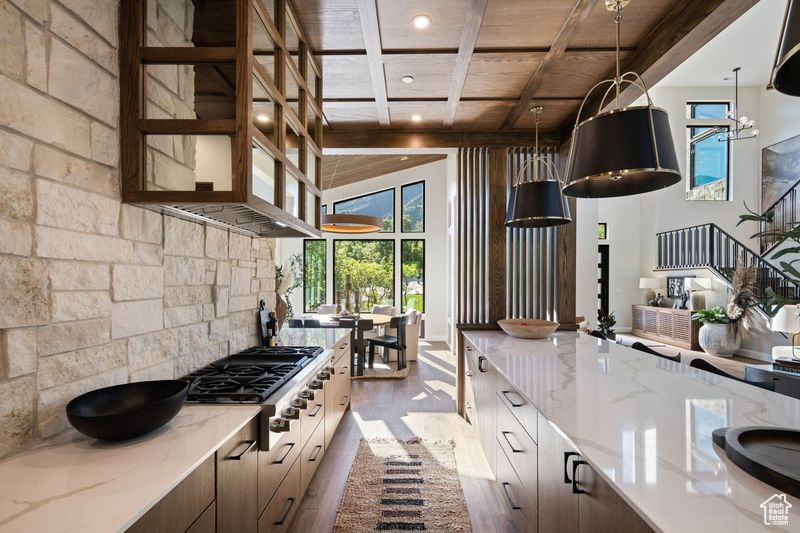 Kitchen featuring beamed ceiling, hardwood / wood-style floors, light stone countertops, and wooden ceiling