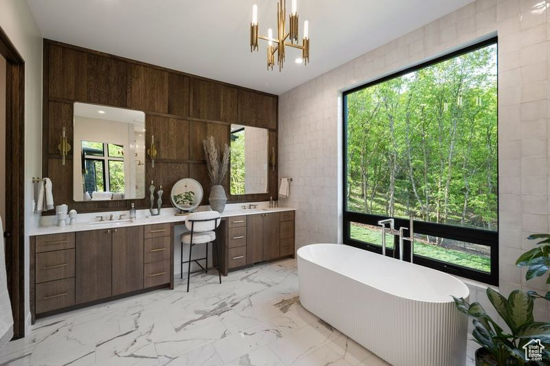 Bathroom with a wealth of natural light, oversized vanity, and tile walls