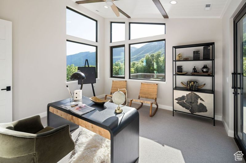 Carpeted office featuring a mountain view, ceiling fan, and lofted ceiling