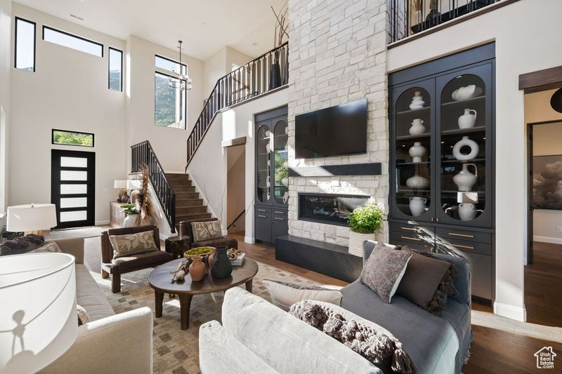 Living room with a high ceiling, a fireplace, and hardwood / wood-style floors