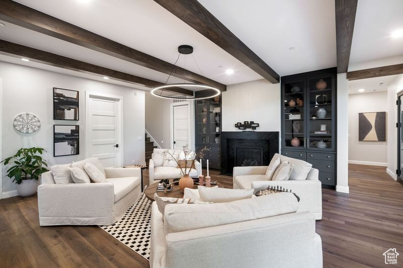 Living room featuring dark wood-type flooring and beam ceiling