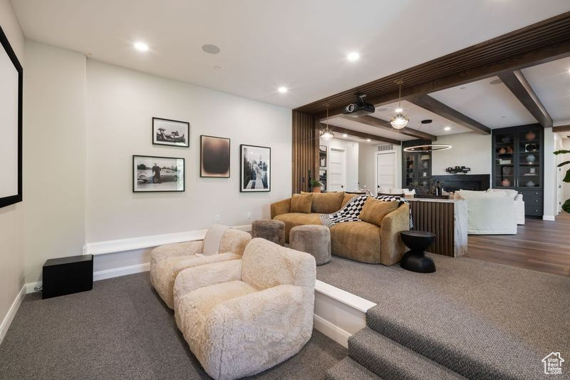 Carpeted living room featuring beamed ceiling