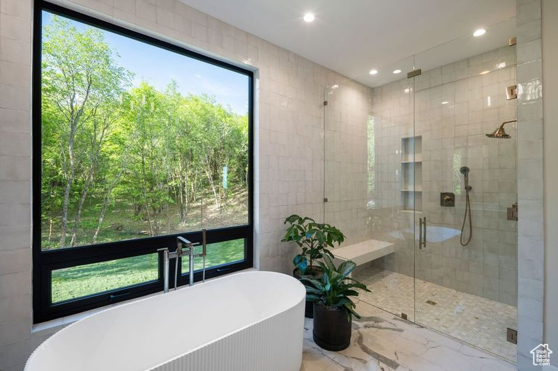 Bathroom featuring tile walls and plus walk in shower