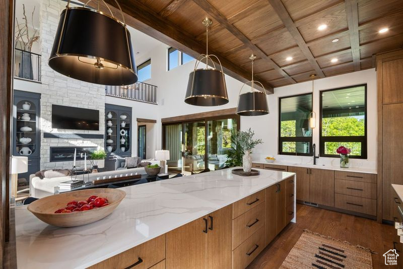 Kitchen with plenty of natural light, beam ceiling, and dark hardwood / wood-style flooring