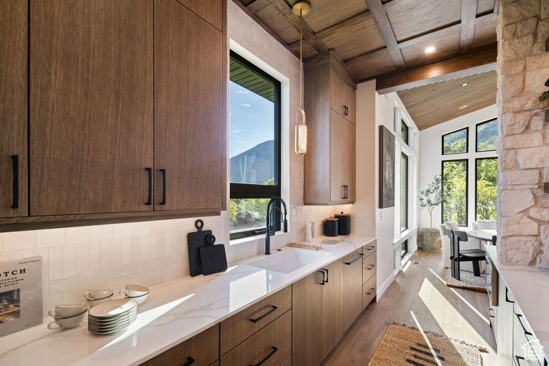 Kitchen with plenty of natural light, lofted ceiling with beams, sink, and wooden ceiling