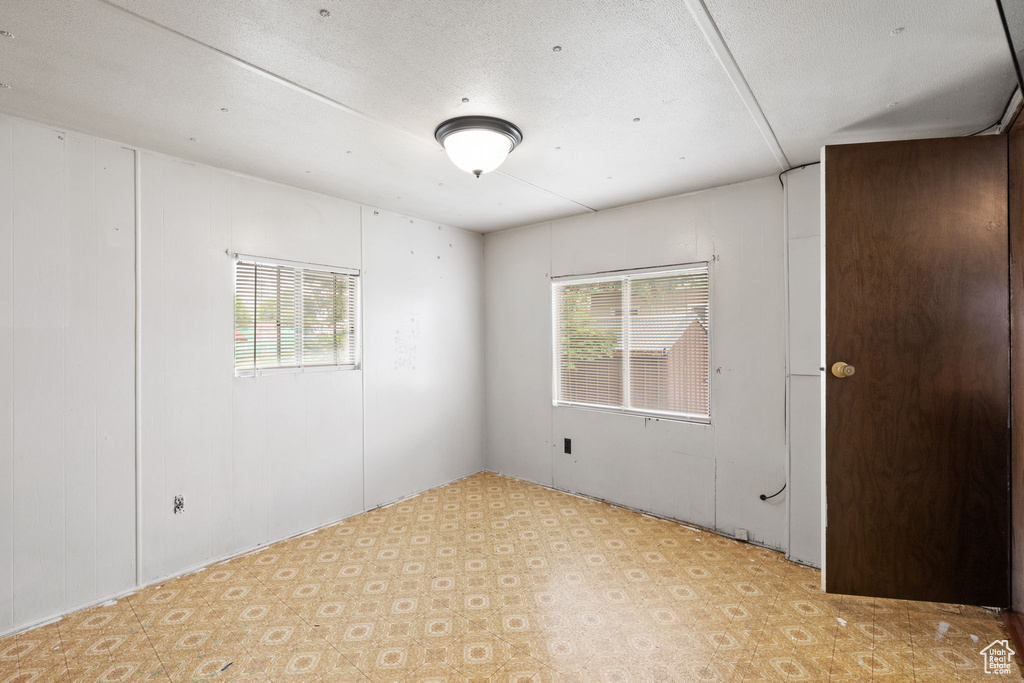 Unfurnished room featuring a wealth of natural light and a textured ceiling