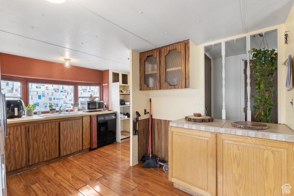 Kitchen with sink, dishwasher, and light wood-type flooring
