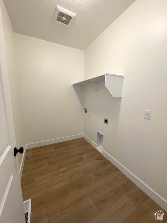 Laundry area with hookup for an electric dryer, hookup for a washing machine, and dark wood-type flooring