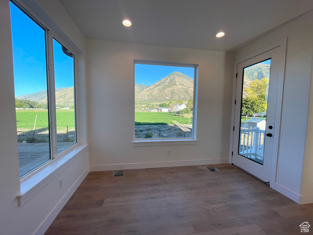 Interior space with light hardwood / wood-style floors, a mountain view, and plenty of natural light