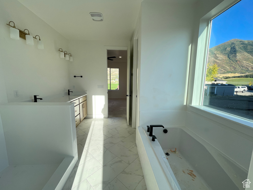 Bathroom with a mountain view, vanity, and a bathing tub