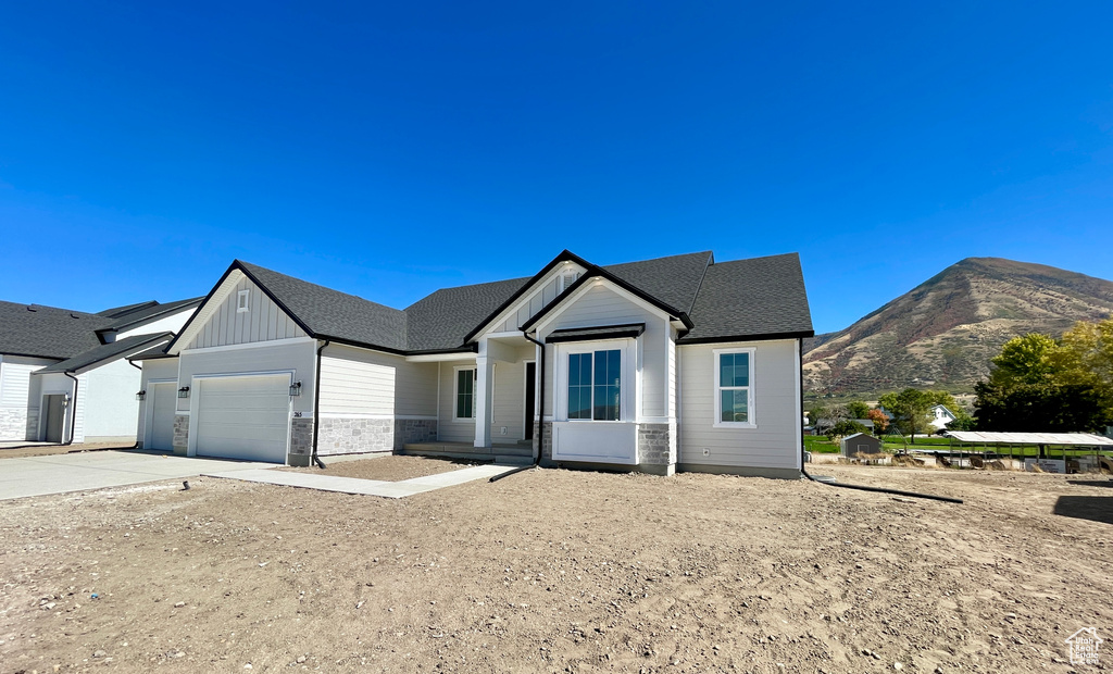 View of front of property with a garage and a mountain view