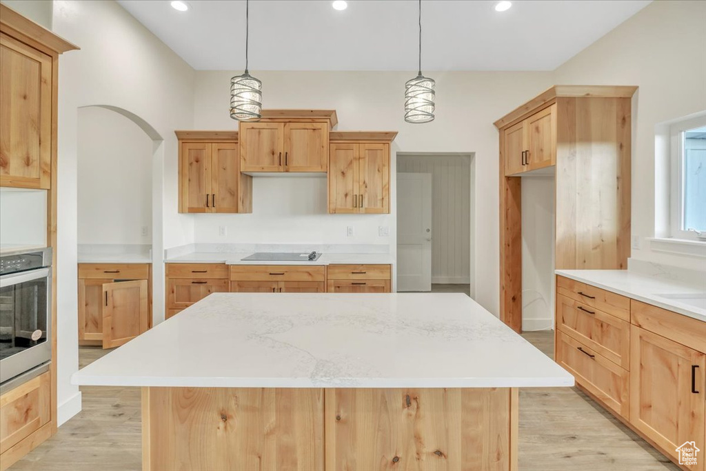 Kitchen featuring a center island, light hardwood / wood-style flooring, oven, and black electric cooktop