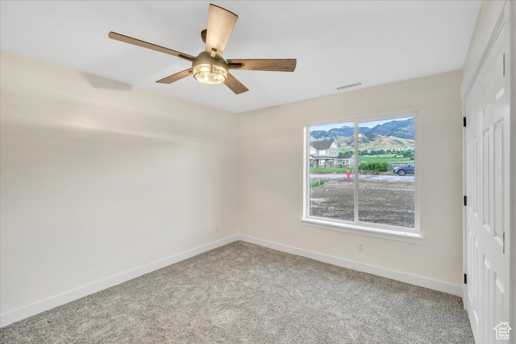 Unfurnished bedroom with ceiling fan, a closet, and carpet flooring