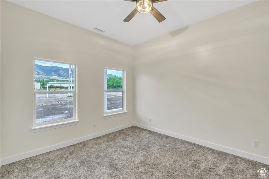 Empty room featuring carpet and ceiling fan