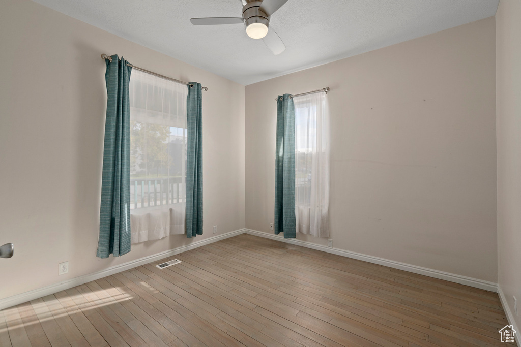 Spare room featuring ceiling fan and light wood-type flooring