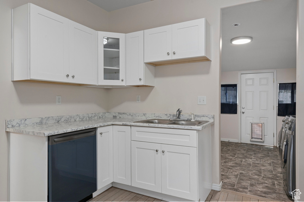 Kitchen featuring tile flooring, washer and clothes dryer, white cabinets, sink, and dishwasher