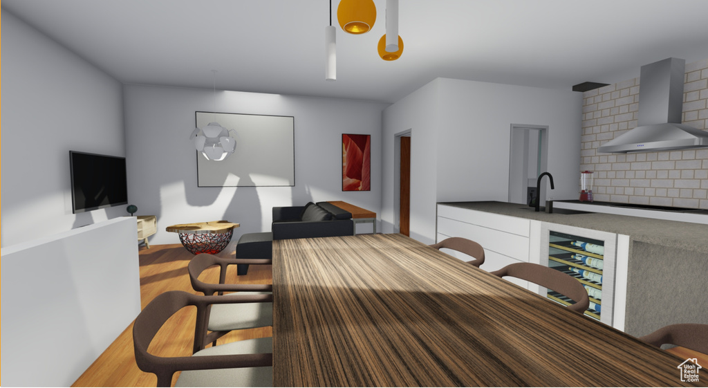 Interior space with wall chimney range hood, sink, tasteful backsplash, and wood-type flooring