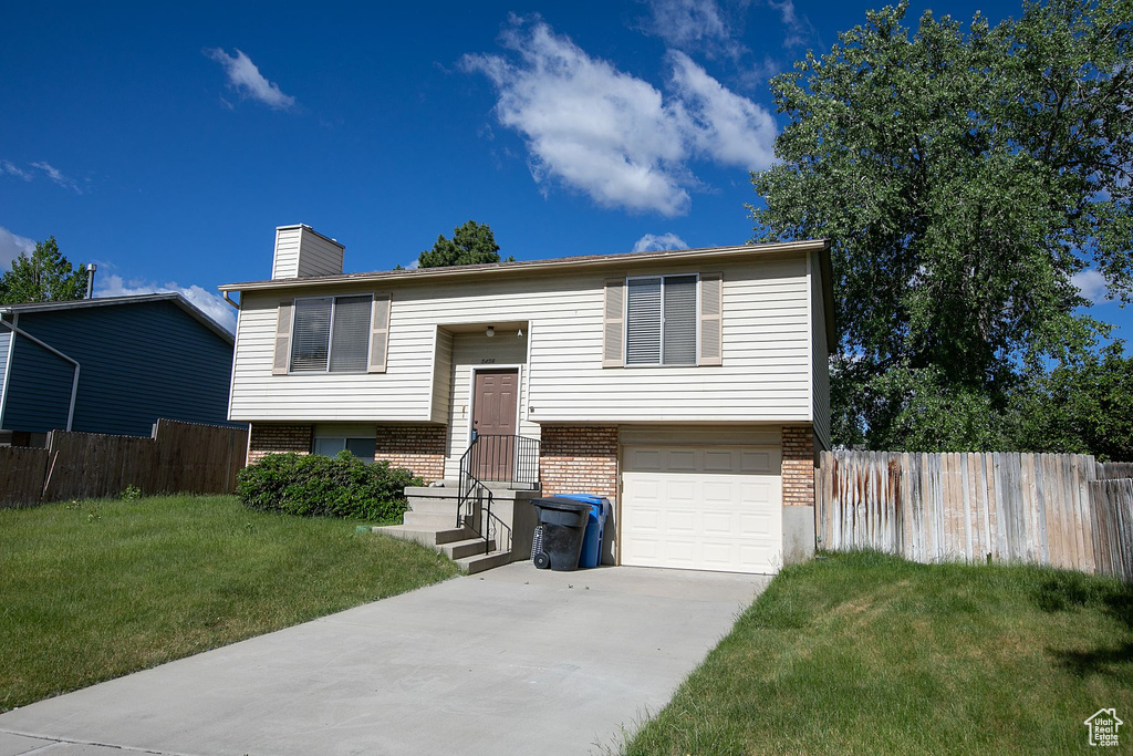 Bi-level home featuring a front yard and a garage