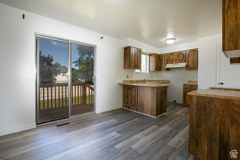 Kitchen with dark hardwood / wood-style floors, a kitchen breakfast bar, and kitchen peninsula