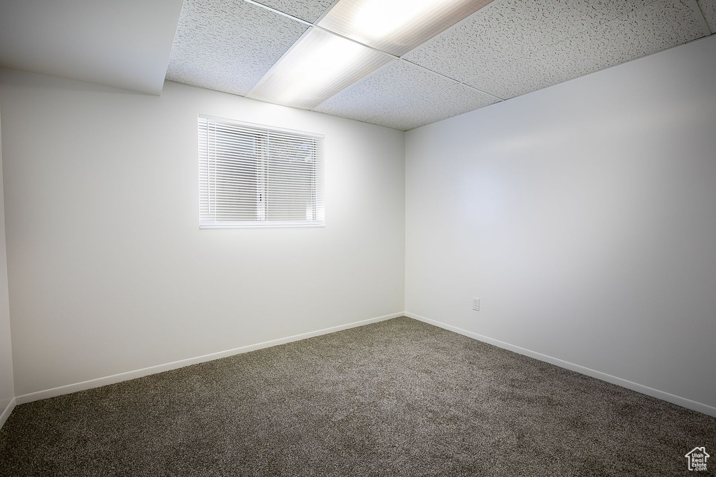 Carpeted empty room featuring a paneled ceiling