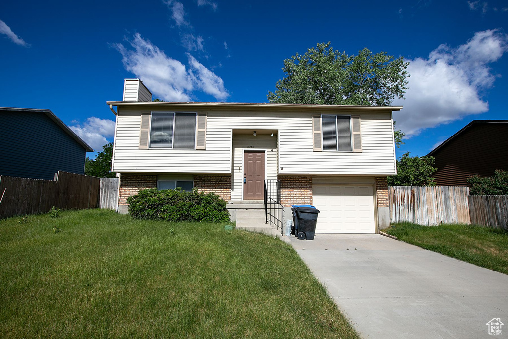 Raised ranch with a garage and a front yard