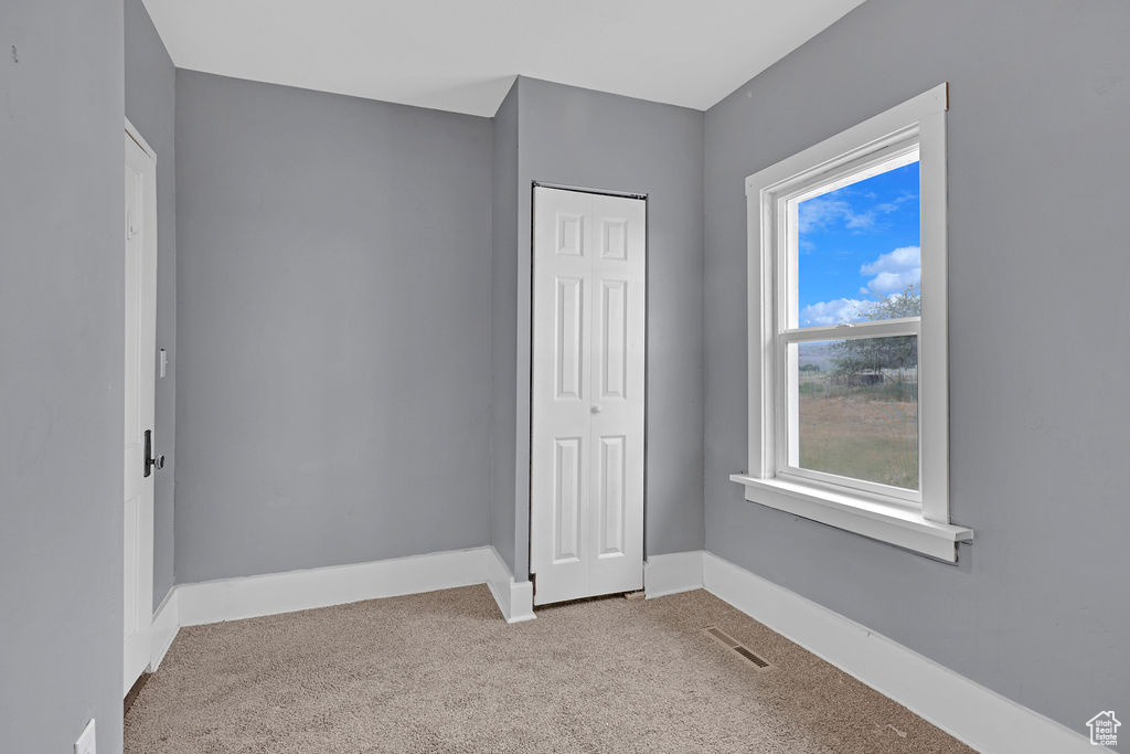 Unfurnished bedroom featuring a closet and carpet floors