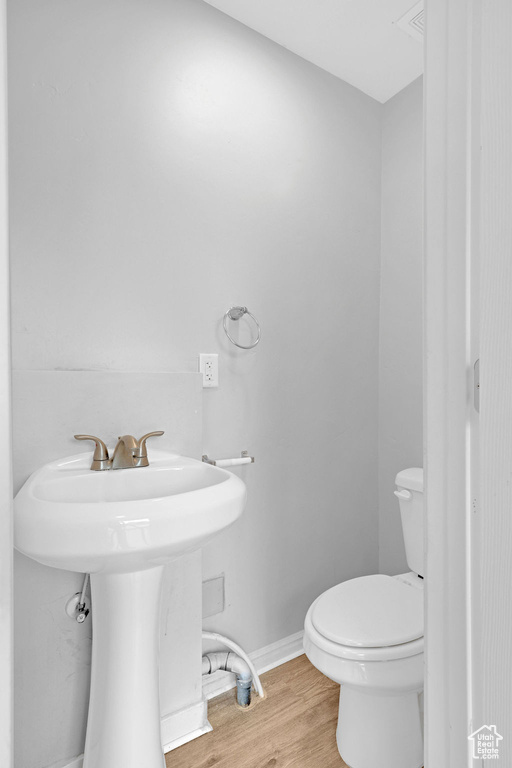 Bathroom featuring sink, toilet, and hardwood / wood-style floors