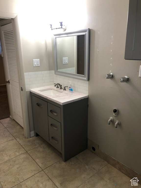 Bathroom with backsplash, vanity, and tile floors