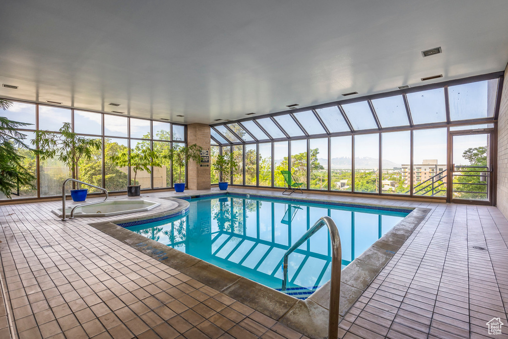 View of swimming pool with a patio and a hot tub