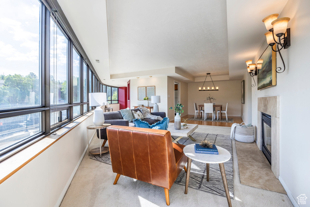 Carpeted living room with a premium fireplace and a chandelier