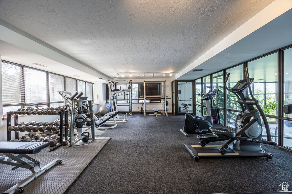 Gym featuring a textured ceiling and track lighting