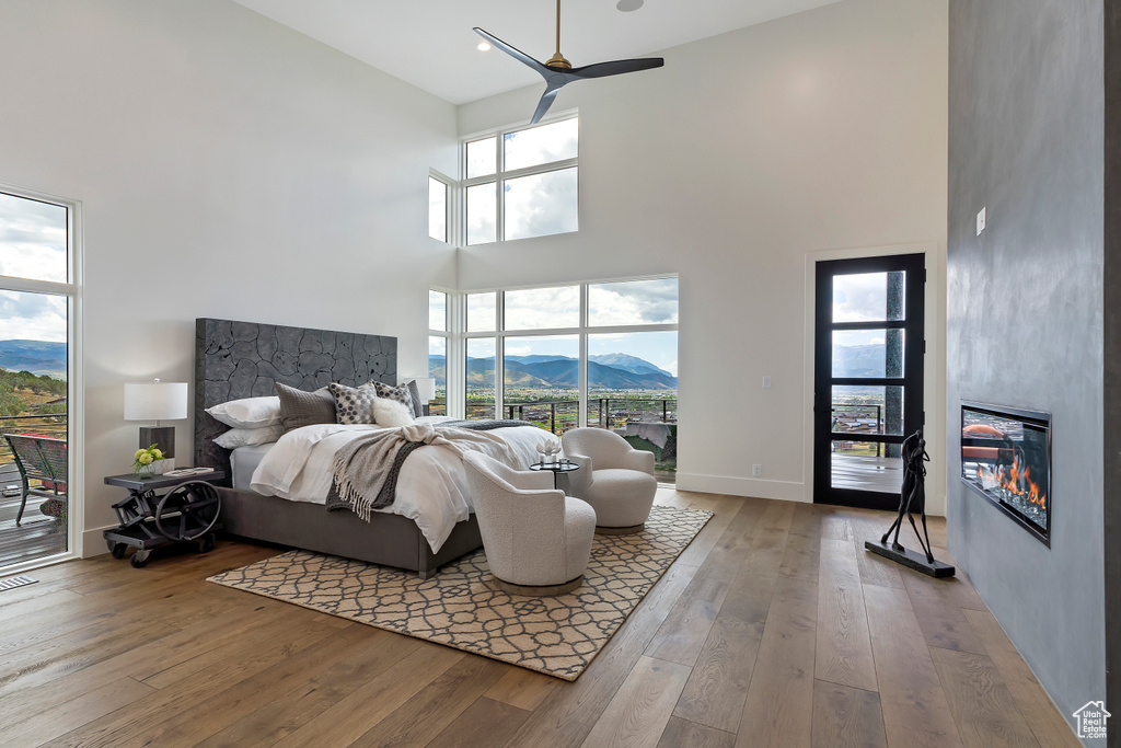 Bedroom with light hardwood / wood-style floors, a mountain view, and a high ceiling