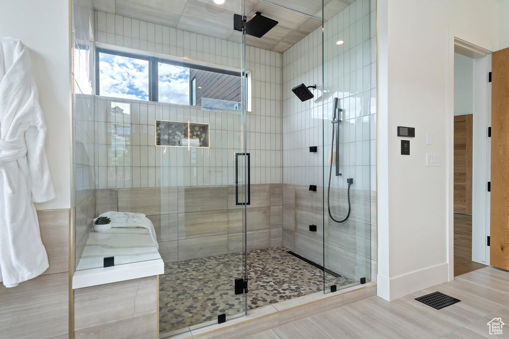 Bathroom featuring tile patterned flooring and a shower with door