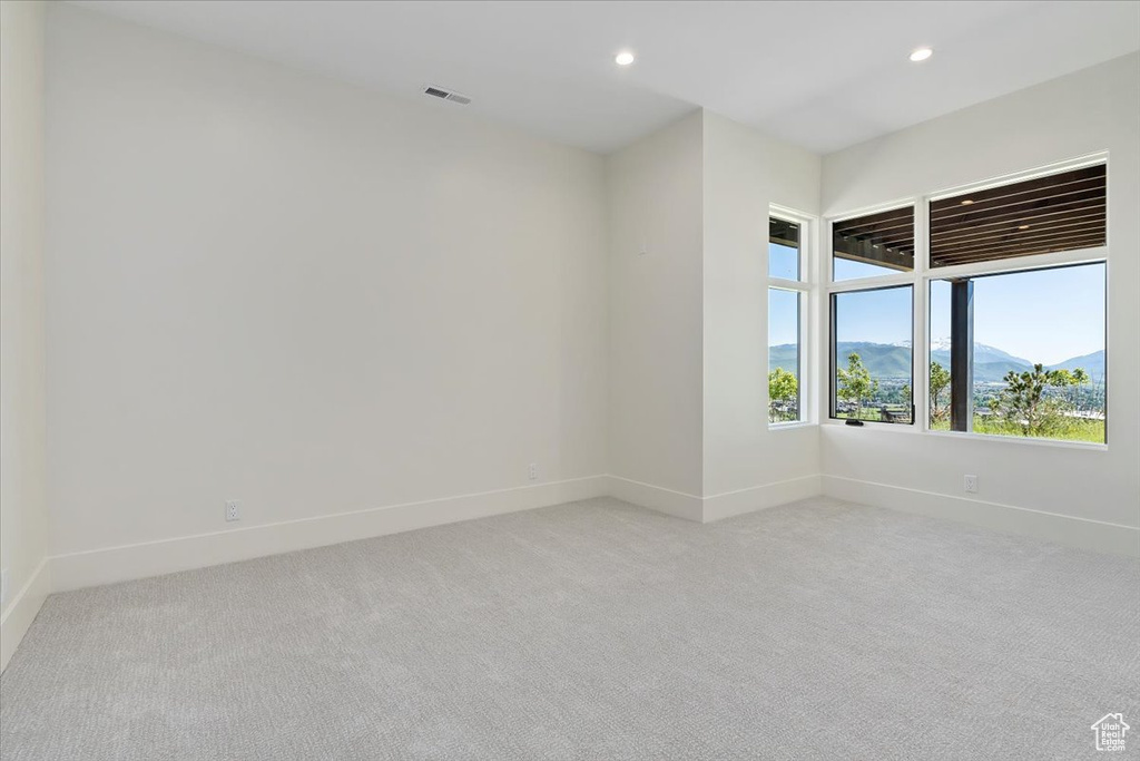 Empty room featuring carpet and a mountain view