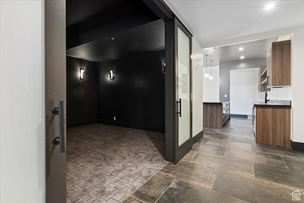 Corridor with sink and dark tile flooring