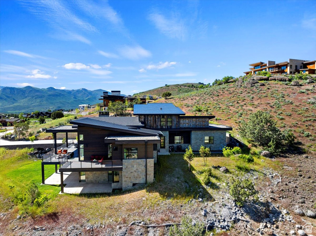 Rear view of house with a mountain view, outdoor lounge area, and a patio