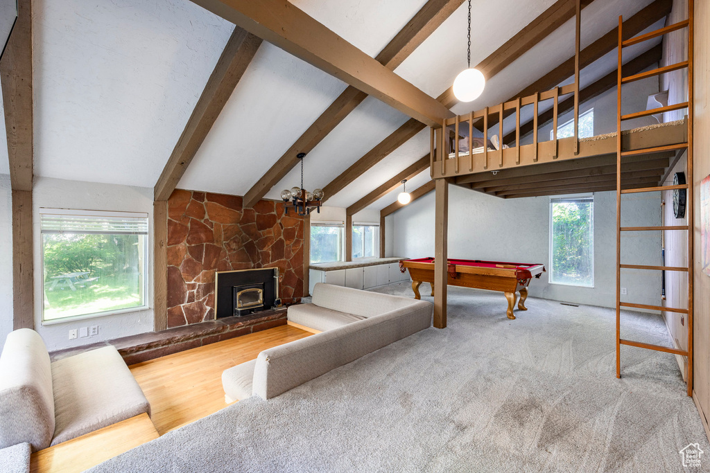 Living room featuring billiards, vaulted ceiling with beams, a fireplace, and a wealth of natural light