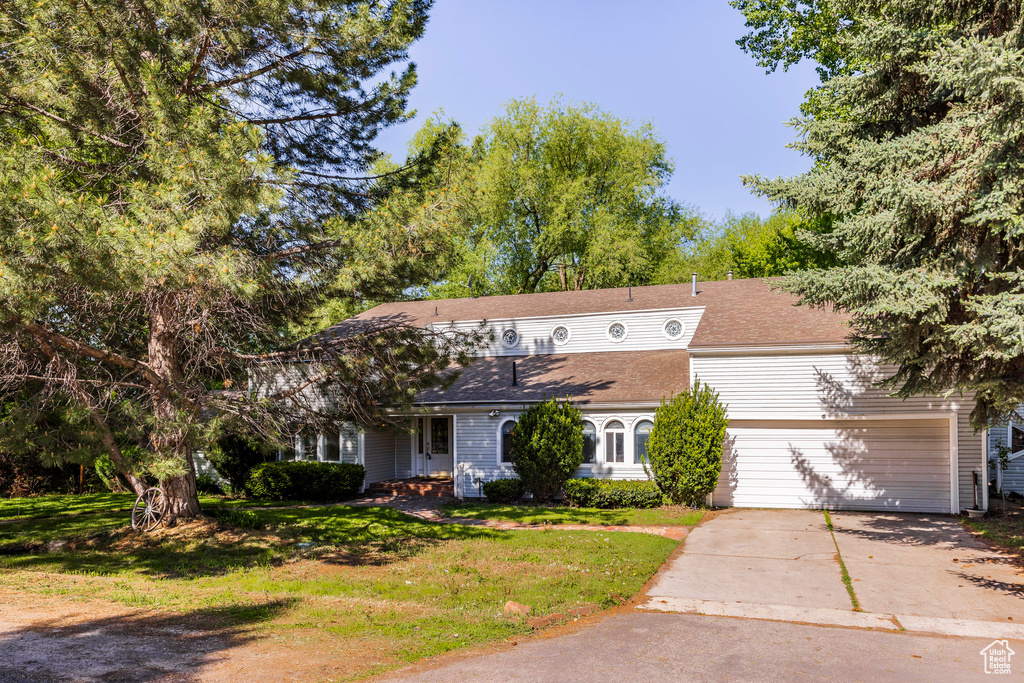 View of front facade with a garage and a front lawn