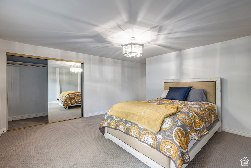 Carpeted bedroom featuring an inviting chandelier