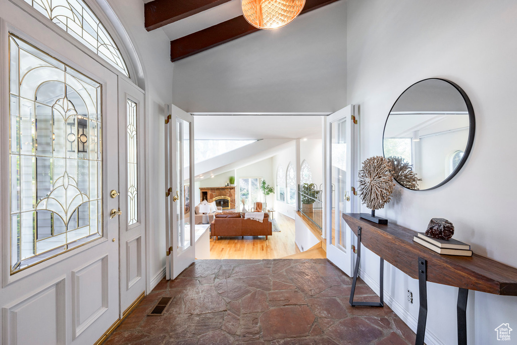 Entryway featuring dark tile flooring and lofted ceiling with beams