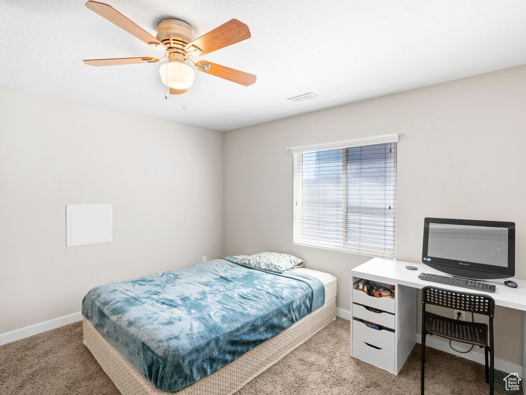 Carpeted bedroom with ceiling fan