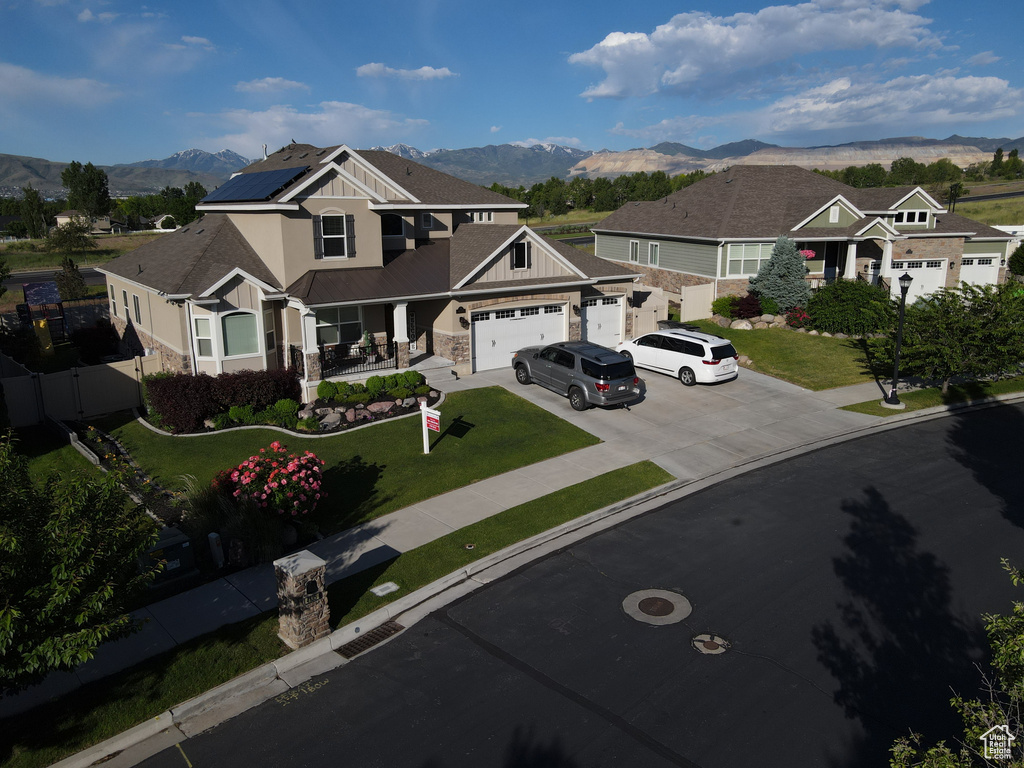 Craftsman-style house featuring a front yard, a garage, a mountain view, and solar panels