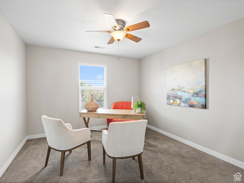 Carpeted dining area with ceiling fan