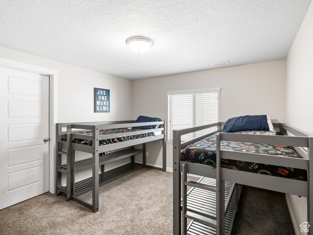 Carpeted bedroom with a textured ceiling