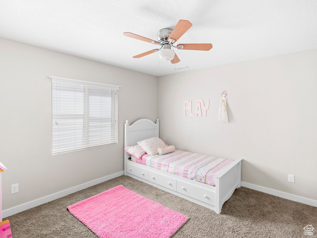 Carpeted bedroom featuring ceiling fan